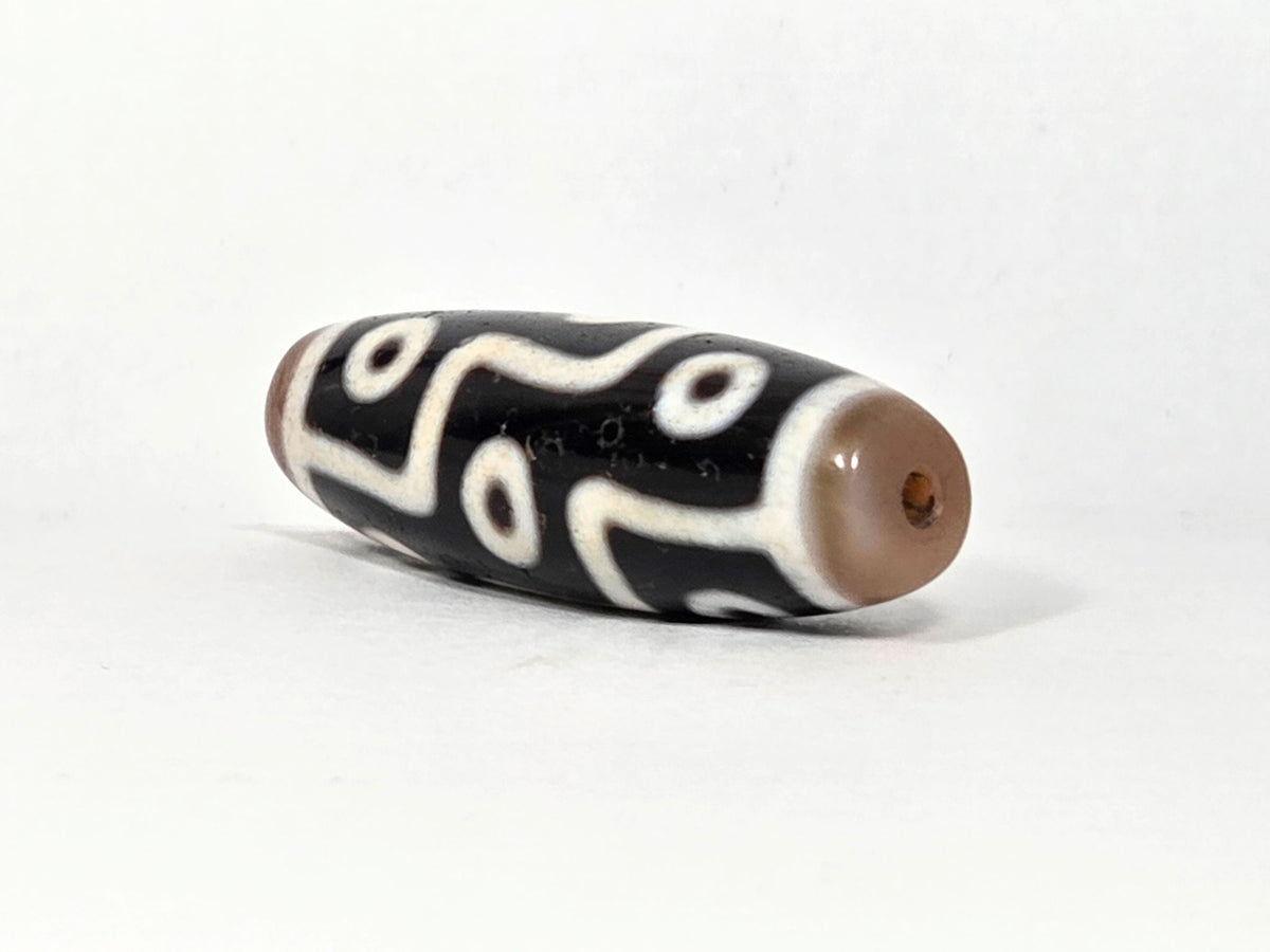 At-061926-9E6BS angled tip A, warm sandy-tan cap, reddish-brown drill interior, wide barrel form, unretouched