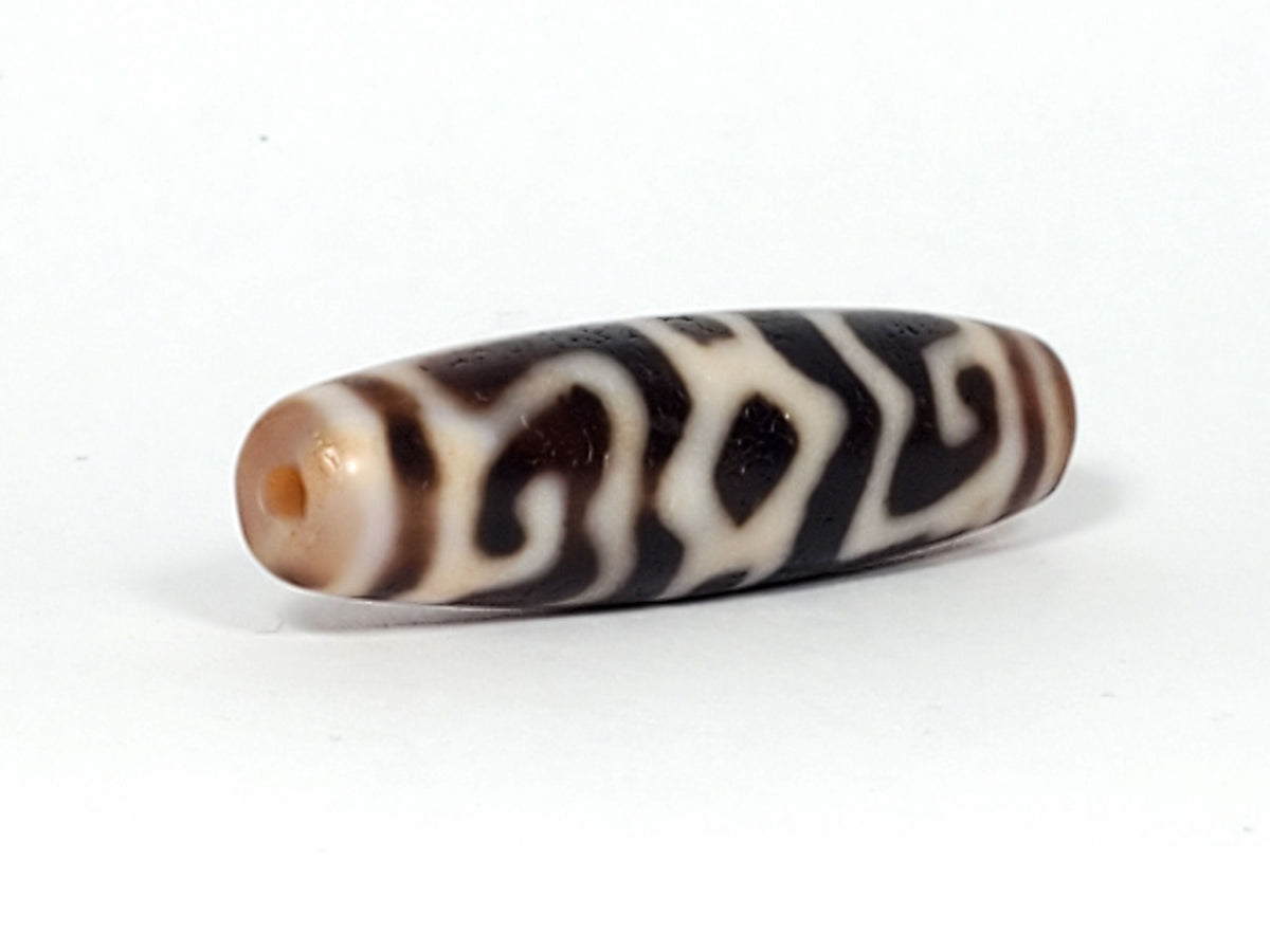 Ac-061926-GRDC angled tip B, diamond lozenge voids, dense cream-white motif, honey-brown end cap, unretouched