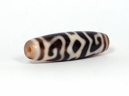 Ac-061926-GRDC angled tip B, diamond lozenge voids, dense cream-white motif, honey-brown end cap, unretouched