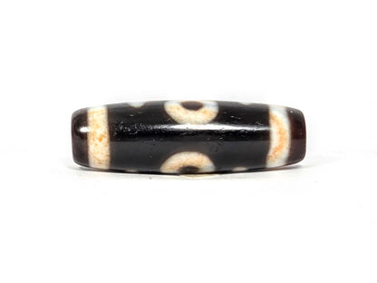 V-021326-BenBS Benefactor dzi bead, fourth face, cream-dark composition, pitch-black and dark brown zones, unretouched.