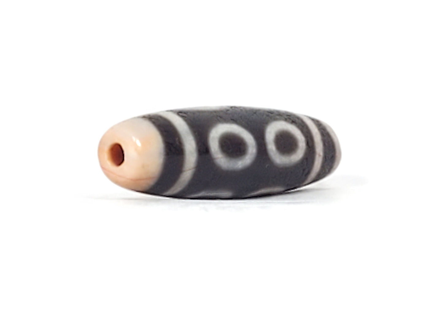 V-092924-8EBS Eight Eye dzi bead, opposite angled end view, peachy-apricot cap, deep dark brown body, unretouched
