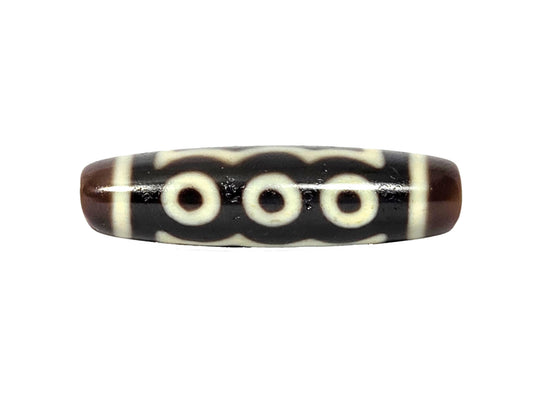 Five-eye dzi bead, dark brown agate, white eye motifs, wave pattern, polished surface, visible drill hole, 41mm elongated barrel shape