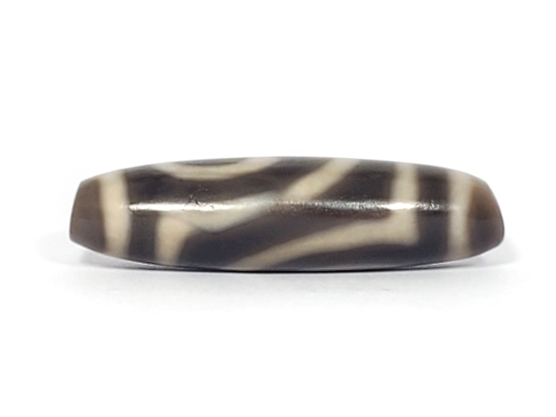 Second face of ancient Two Eye Dzi — sweeping cream pattern on deep grey-brown agate