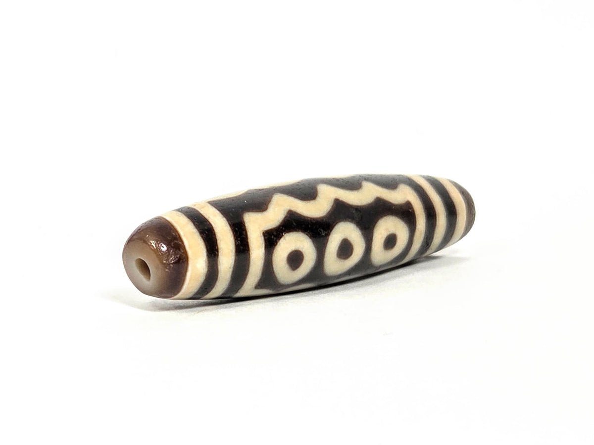Ac-071026-7E ancient seven eye dzi angled view drill end A warm brown end cap small clean hole unretouched