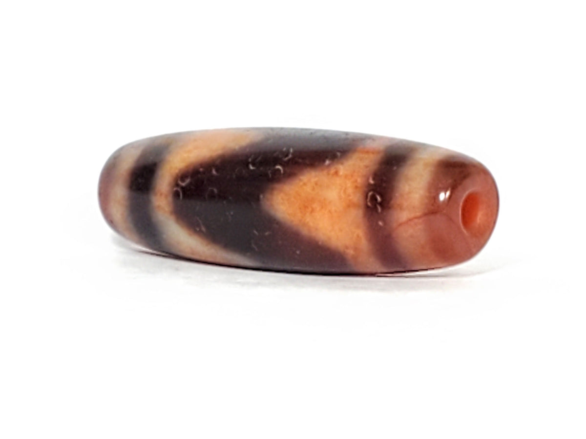Ac-071026-TaBS ancient tasso dzi angled view drill end B orange-red end cap tasso chevrons visible unretouched