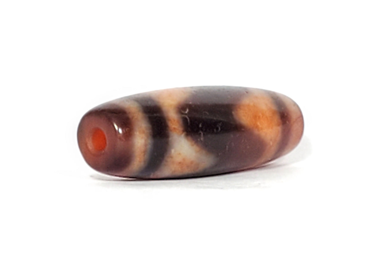 Ac-071026-TaBS ancient tasso dzi angled view drill end A bright orange-red end cap small clean hole unretouched