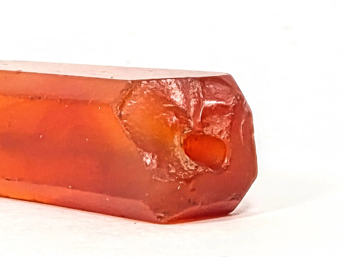 Ancient Indus Valley beveled carnelian bead, translucent orange-red, visible drill hole, surface chipping, natural patina, 28mm