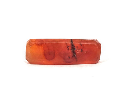 Anc-0626-CBev2, bottom face showing internal oval inclusions and dark stress mark within translucent carnelian, unretouched