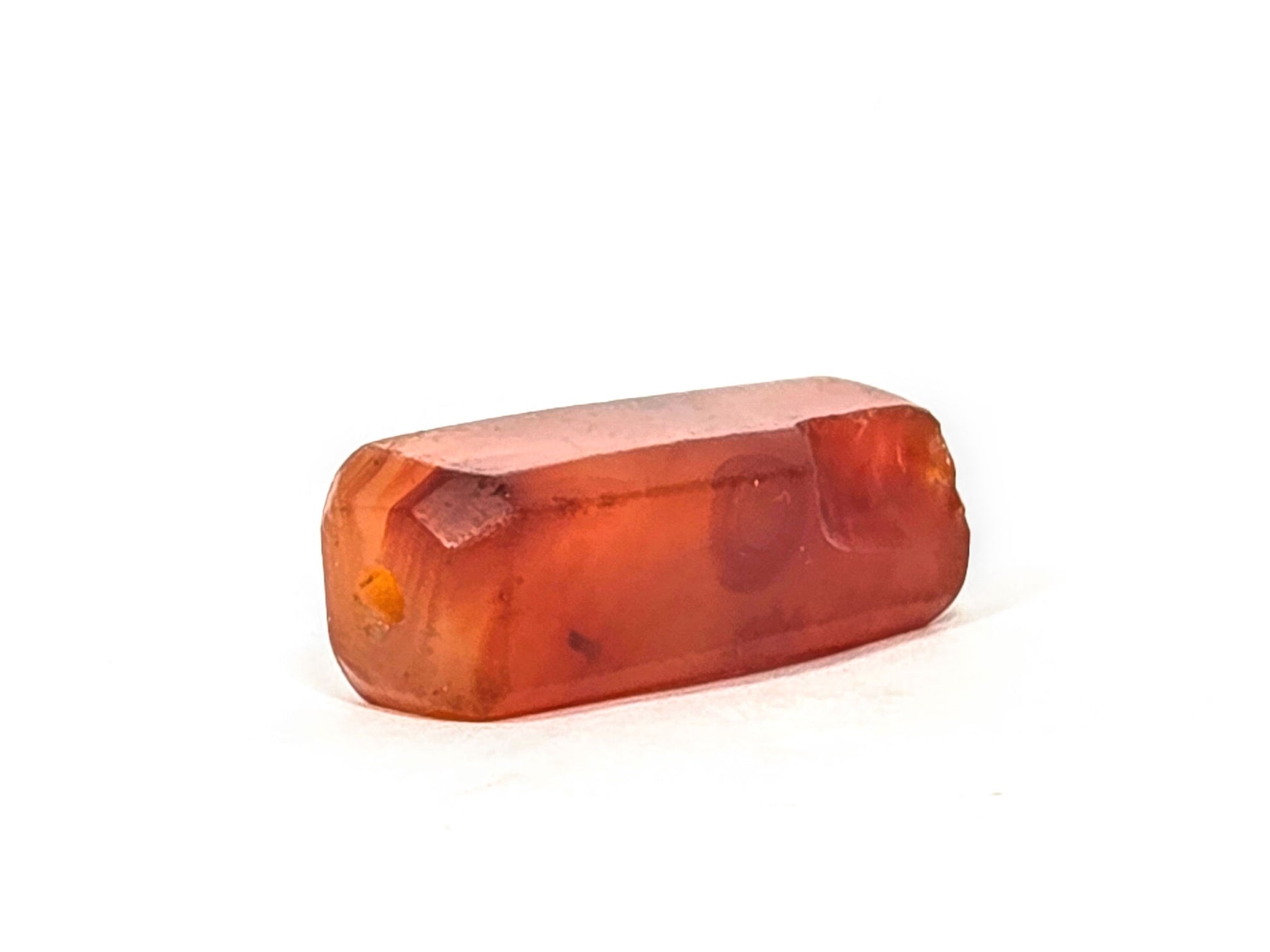 Anc-0626-CBev2, End B angled view, intact drill hole, lesser chipping, translucent orange-red carnelian body, unretouched