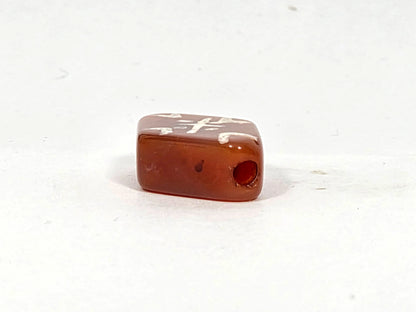 Side and end view of ancient carnelian cross tiger tooth bead showing rectangular flat profile, drill hole aperture, and deep sienna-amber carnelian body, 20.5 mm × 13.5 mm × 6.0 mm