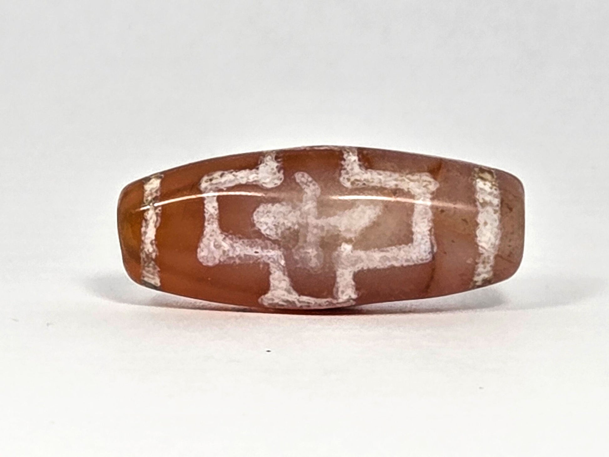Ac-080426-DCCS ancient carnelian dzi bead 29.1×12.2mm, Face A showing double cross-in-cross motif, warm terracotta-orange ground, unretouched