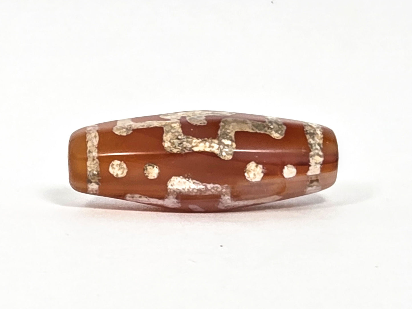 Ac-080426-DCCS ancient carnelian dzi bead 29.1×12.2mm, Face D view with star dots and partial cross, beveled barrel form visible, unretouched