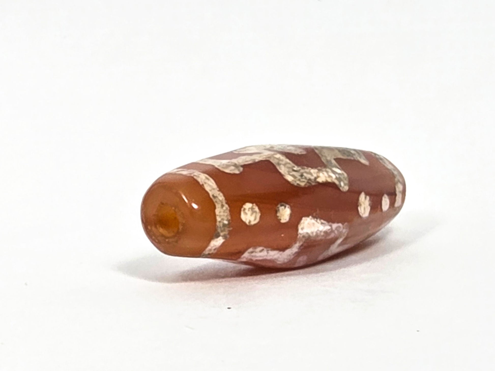 Ac-080426-DCCS ancient carnelian dzi bead 29.1×12.2mm, drill end view showing warm orange translucent carnelian, unretouched