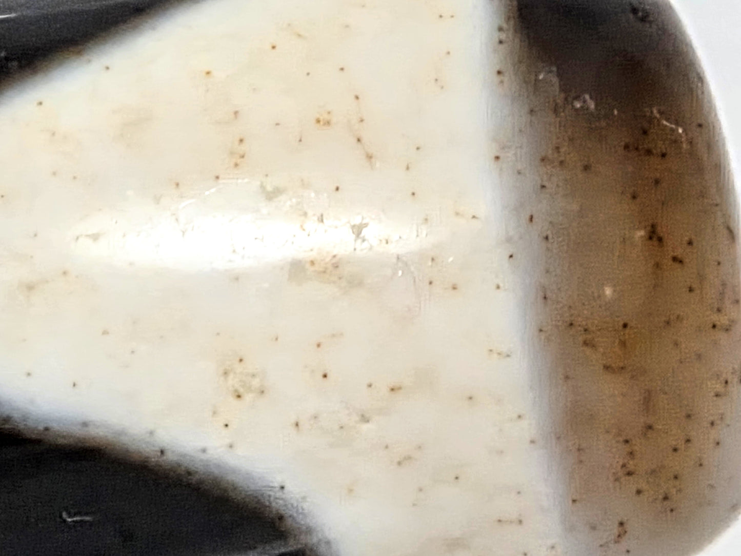 Macro detail of cinnabar bloodspot inclusions at the wave pattern boundary of ancient Tibetan Double Wave Dzi bead — authentic natural agate — unretouched photo — Ancient Dzi Shop