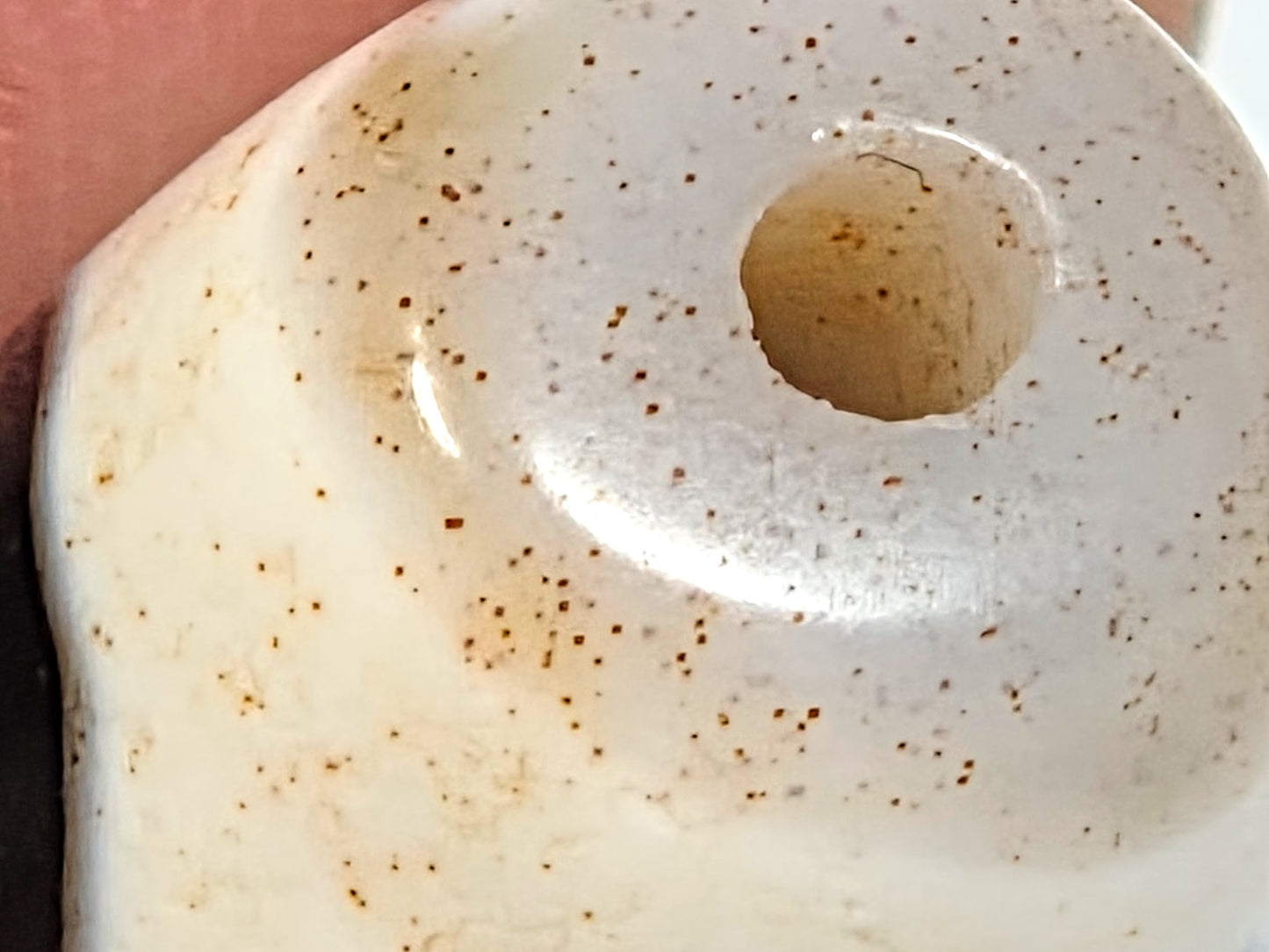 Close-up of natural cinnabar bloodspot inclusions surrounding drill hole of ancient Tibetan Double Wave Dzi bead — rare geological feature — unretouched photo — Ancient Dzi Shop