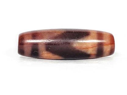 Third face of ancient Tasso Dzi bead — dark mahogany zone with cream Tasso forms, 500–800 years old
