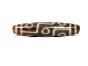 Decorative stone bead with intricate patterns on a white background
