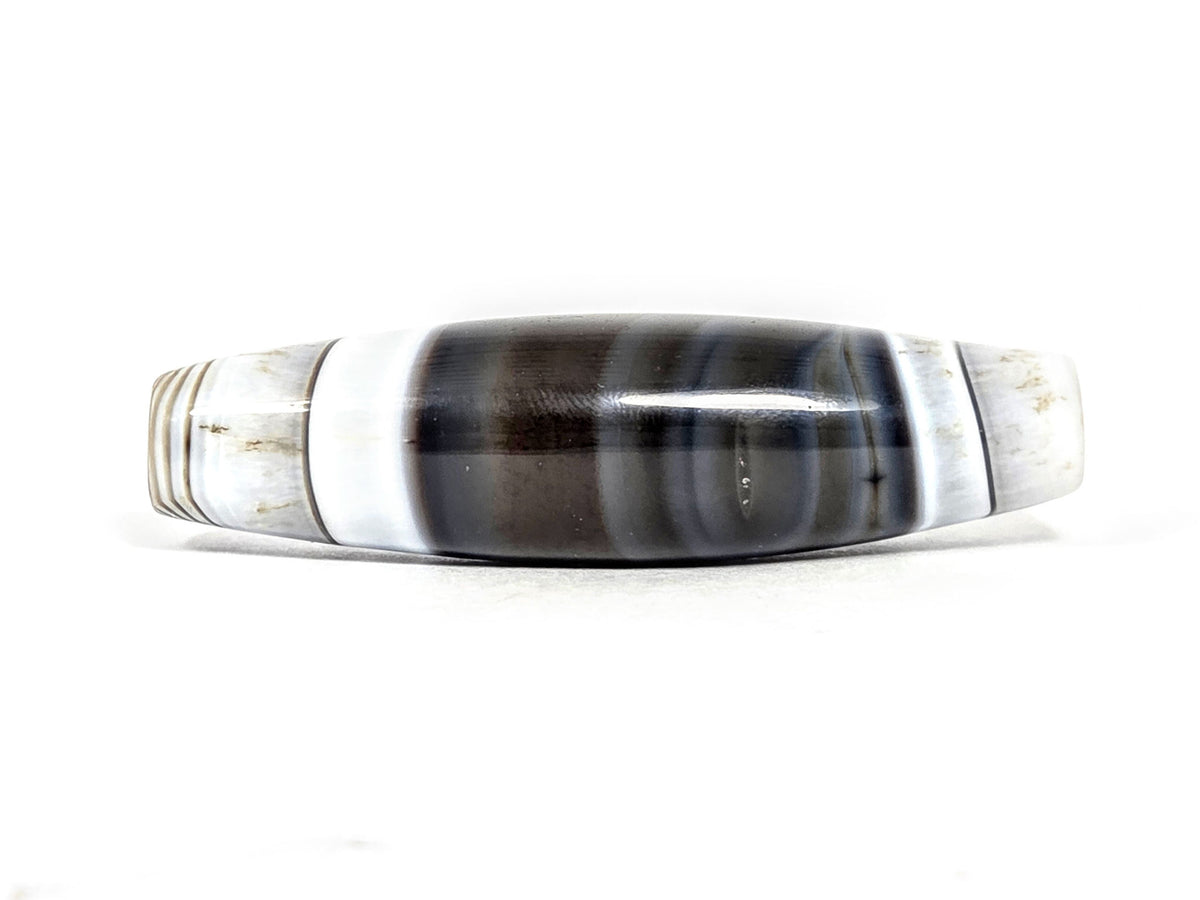 At-N-071426-NBA 63.3×17.4mm antique natural banded agate, face A — pitch-black centre, white bands, unretouched.