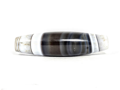 At-N-071426-NBA 63.3×17.4mm antique natural banded agate, face A — pitch-black centre, white bands, unretouched.