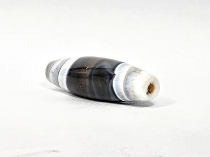 At-N-071426-NBA end angle B — narrower tapered end, dense concentric agate rings, drill opening visible, unretouched.