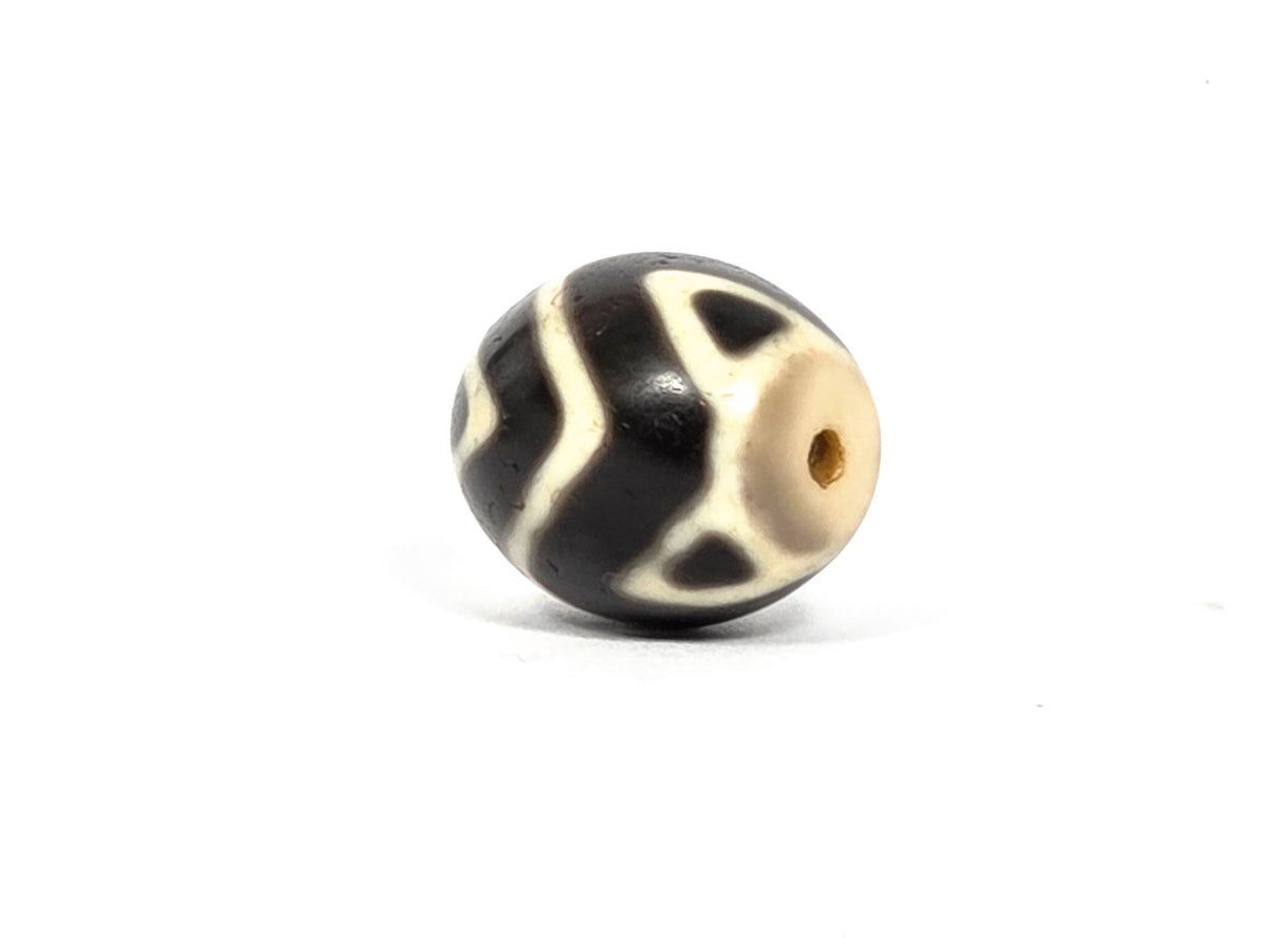 At-080926-WTT antique round Wave Tiger Tooth dzi bead 17.8×15.6mm, equatorial side rotation showing flowing wave lines and cream drill-end oval with warm honey agate interior, unretouched