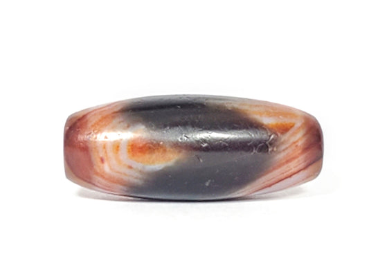 Side view of antique Tasso dzi bead showing black center zone and warm reddish-brown banding, At-052526-TaBS