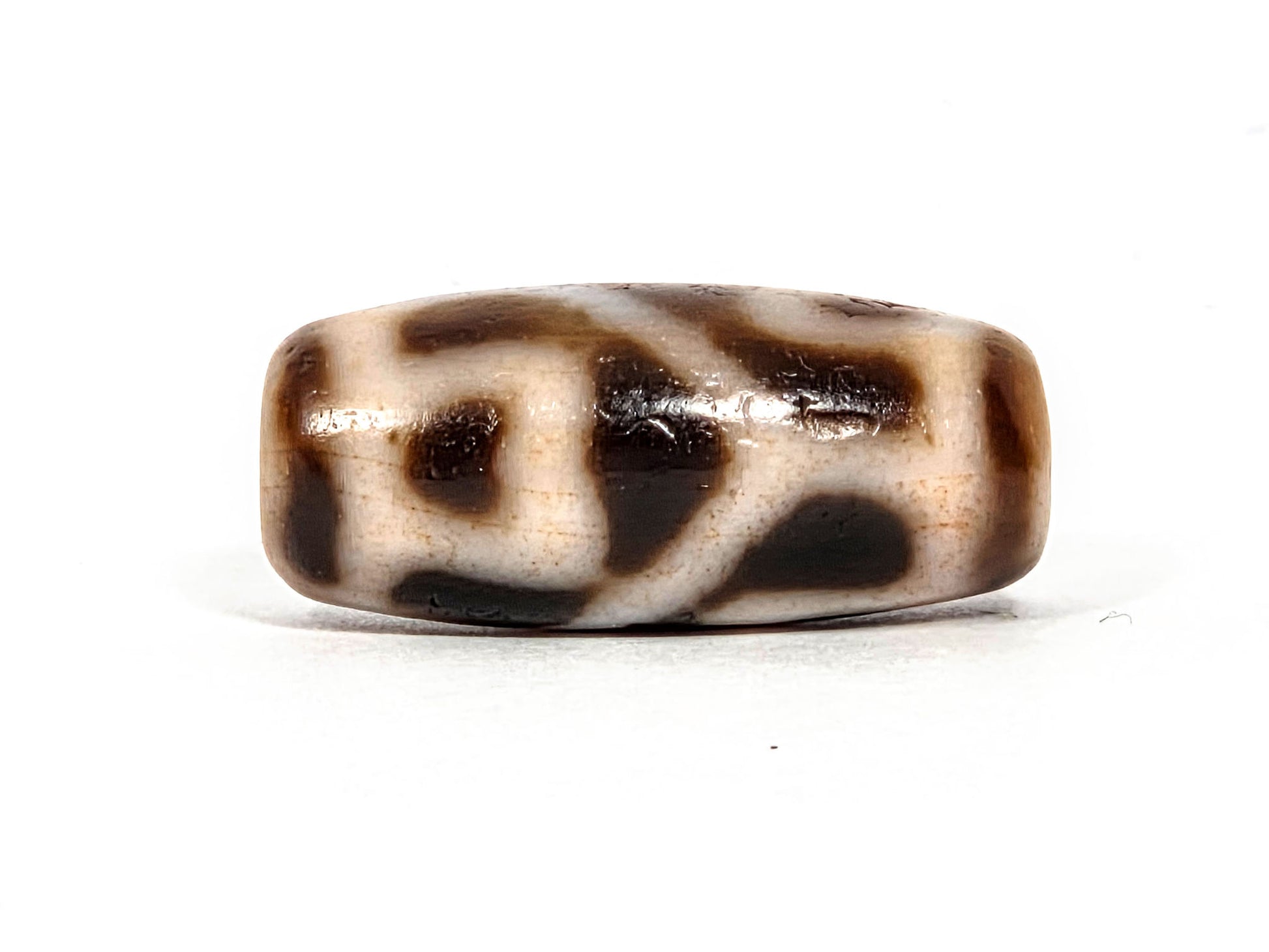 At-080926-6ELCBS antique Six Eye Lotus Cross dzi bead 24.1×10.8mm, Face A showing stepped cross arms and large oval eye form on cream-dominant ground, unretouched