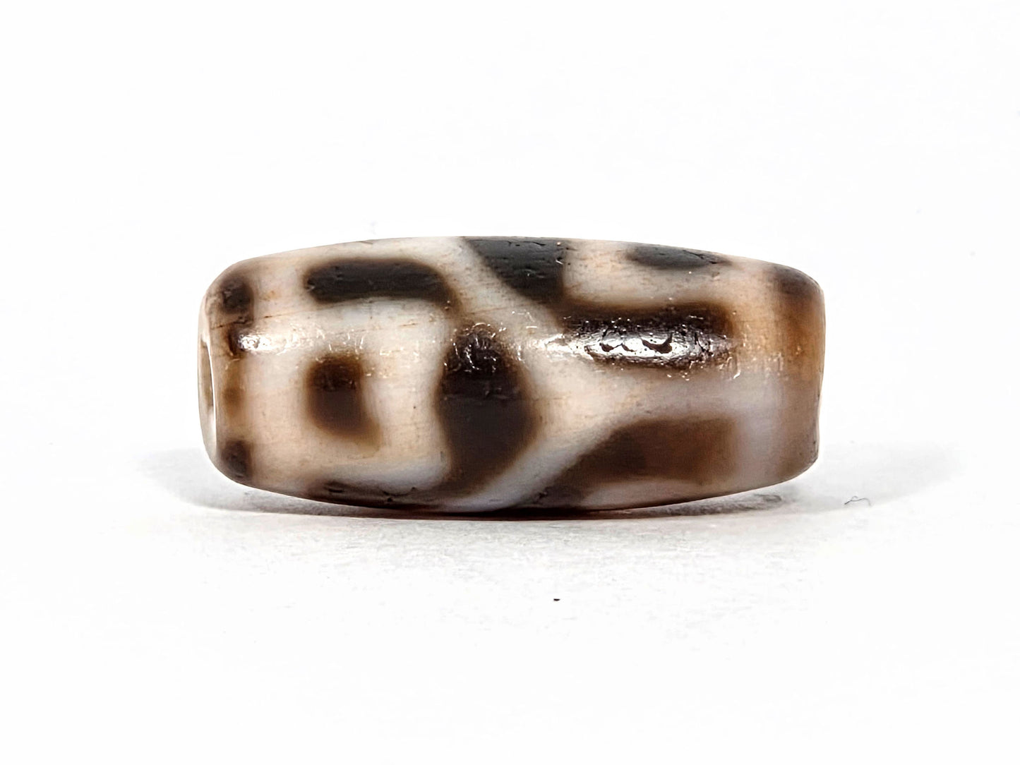 At-080926-6ELCBS antique Six Eye Lotus Cross dzi bead 24.1×10.8mm, Face B showing hook-form upper element and oval lower form on cream ground, unretouched