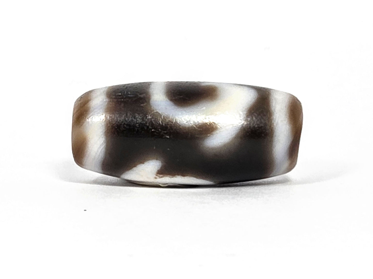 At-080926-RuyiBS antique Ruyi dzi bead 26.2×12.0mm, rotation D showing cream zones dissolving into dark brown ground, diagonal reading, unretouched