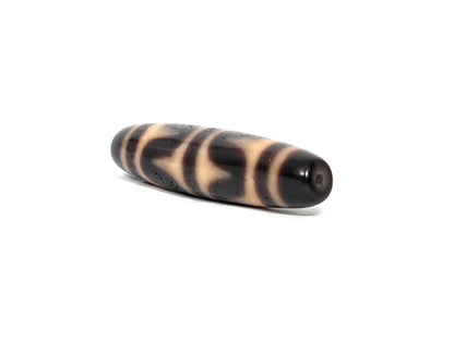 At-090226-DW6 antique double wave dzi 49.4×11.8mm dark agate, angled view drill end cap, unretouched