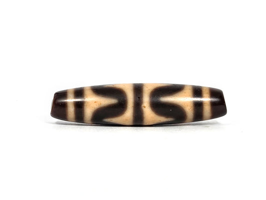 Antique Tibetan double wave dzi bead (AT-092826-DW3), first lateral profile showing dark brown opposing wave forms in three panels on warm honey-tan agate ground, 49.7 mm, 200–400 years old