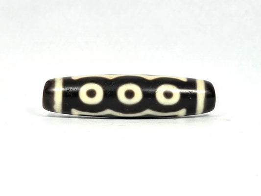Antique Tibetan five-eye dzi bead (AT-100826-5E), three-eye face showing three cream-white eye rings in a row connected by undulating wave lines on deep dark brown agate, 49.4 mm, 200–400 years old
