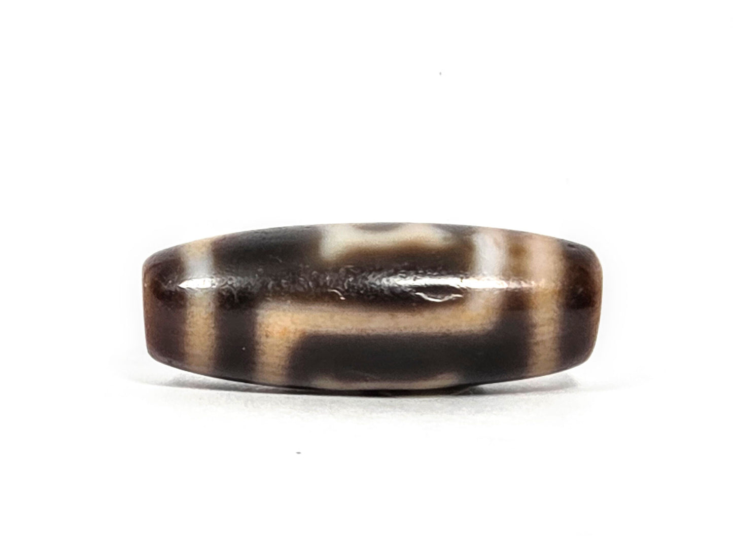At-082326-GTBS antique Green Tara dzi bead 30.3×11.3mm, opposite turn showing motif transitions and warm dark brown ground character, unretouched