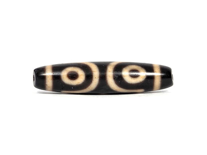 Three eye dzi bead in black agate with cream bands and circular motifs, polished surface, 50.7mm