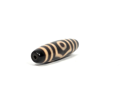Black agate three-eye dzi bead with cream striped pattern and drilled hole, 50.7×11.8mm