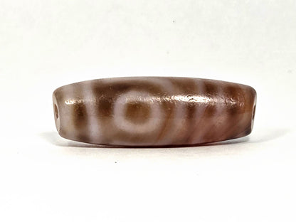 At-080426-2EBS antique two eye dzi bead 38.0×13.1mm, Face A showing two eye motif on warm banded agate ground, unretouched