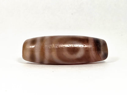 At-080426-2EBS antique two eye dzi bead 38.0×13.1mm, Face B showing eye on banded agate ground with warm brown striations, unretouched