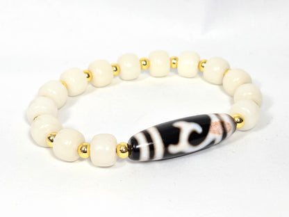 Bracelet featuring antique Tibetan Green Tara Dzi bead with bloodspots, 37.1mm × 11.5mm, with 14 white bodhi root beads 10mm × 8mm and gold-tone spacers — unretouched photo — Ancient Dzi Shop