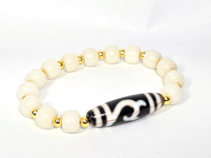 Reverse side of antique Green Tara Dzi bracelet showing natural amber striations on focal bead, white bodhi root rounds and gold-tone spacers — unretouched photo — Ancient Dzi Shop