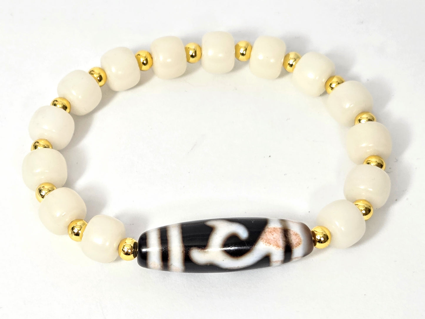 Overhead view of antique Green Tara Dzi bracelet with 14 white bodhi root beads and gold-tone spacers — antique Tibetan dzi focal piece, 200+ years old — unretouched photo — Ancient Dzi Shop