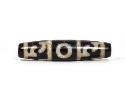Third lateral profile of new Taiwan three-eye and Guru Rinpoche ritual paraphernalia dzi bead showing full motif composition, cream-white pattern on pitch-black agate, 58 mm × 13.5 mm