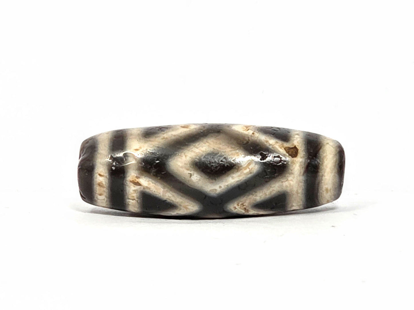 Second face of ancient Three Diamond Eye Dzi bead — dark diamond eye and tiger tooth pattern on warm cream natural agate