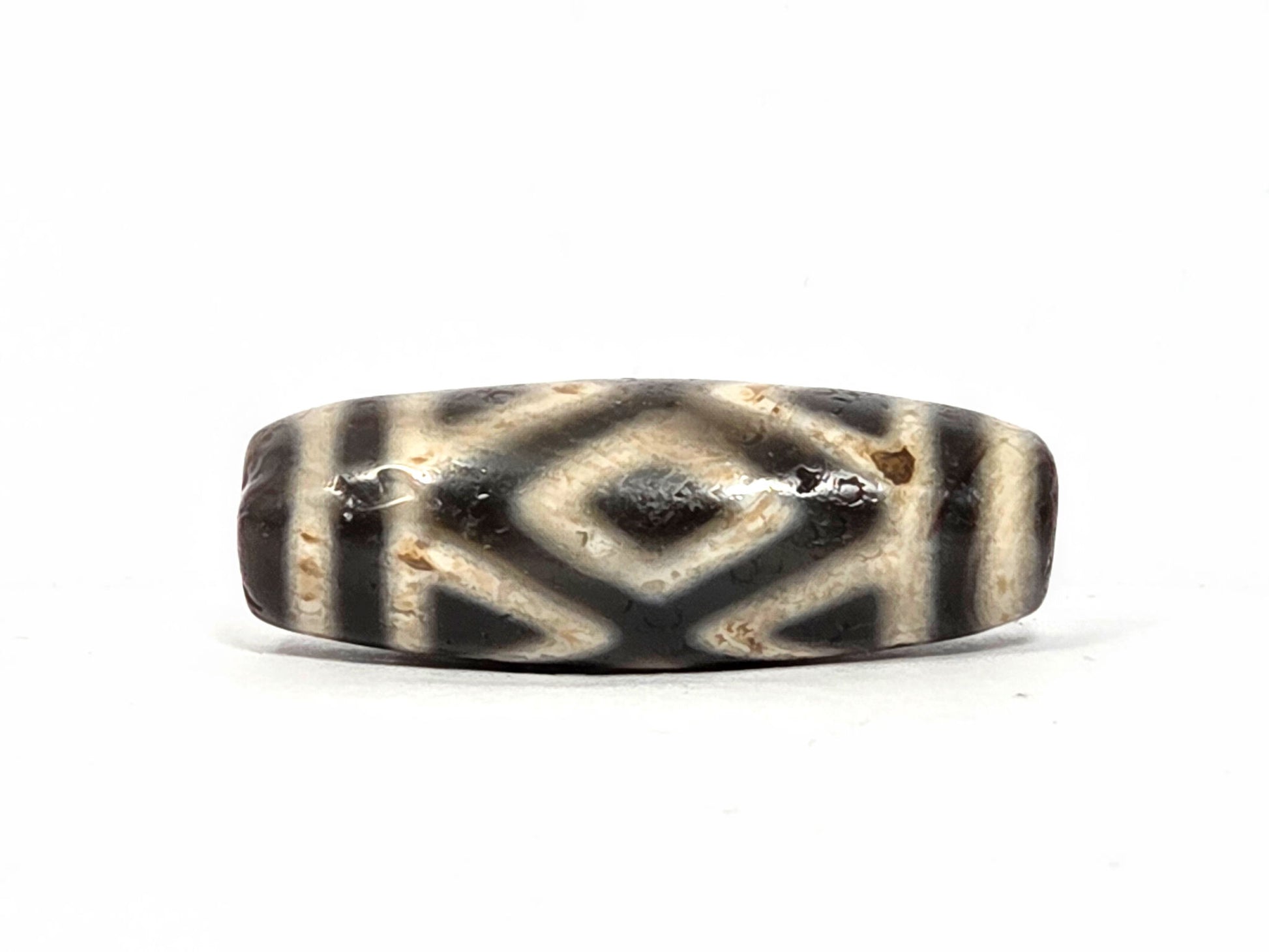 Second face of ancient Three Diamond Eye Dzi bead — dark diamond eye and tiger tooth pattern on warm cream natural agate