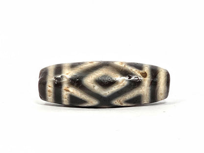 Second face of ancient Three Diamond Eye Dzi bead — dark diamond eye and tiger tooth pattern on warm cream natural agate