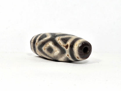 Ac-070926-3DE ancient three diamond eye tiger tooth dzi angled left drill end cream ground age texture unretouched