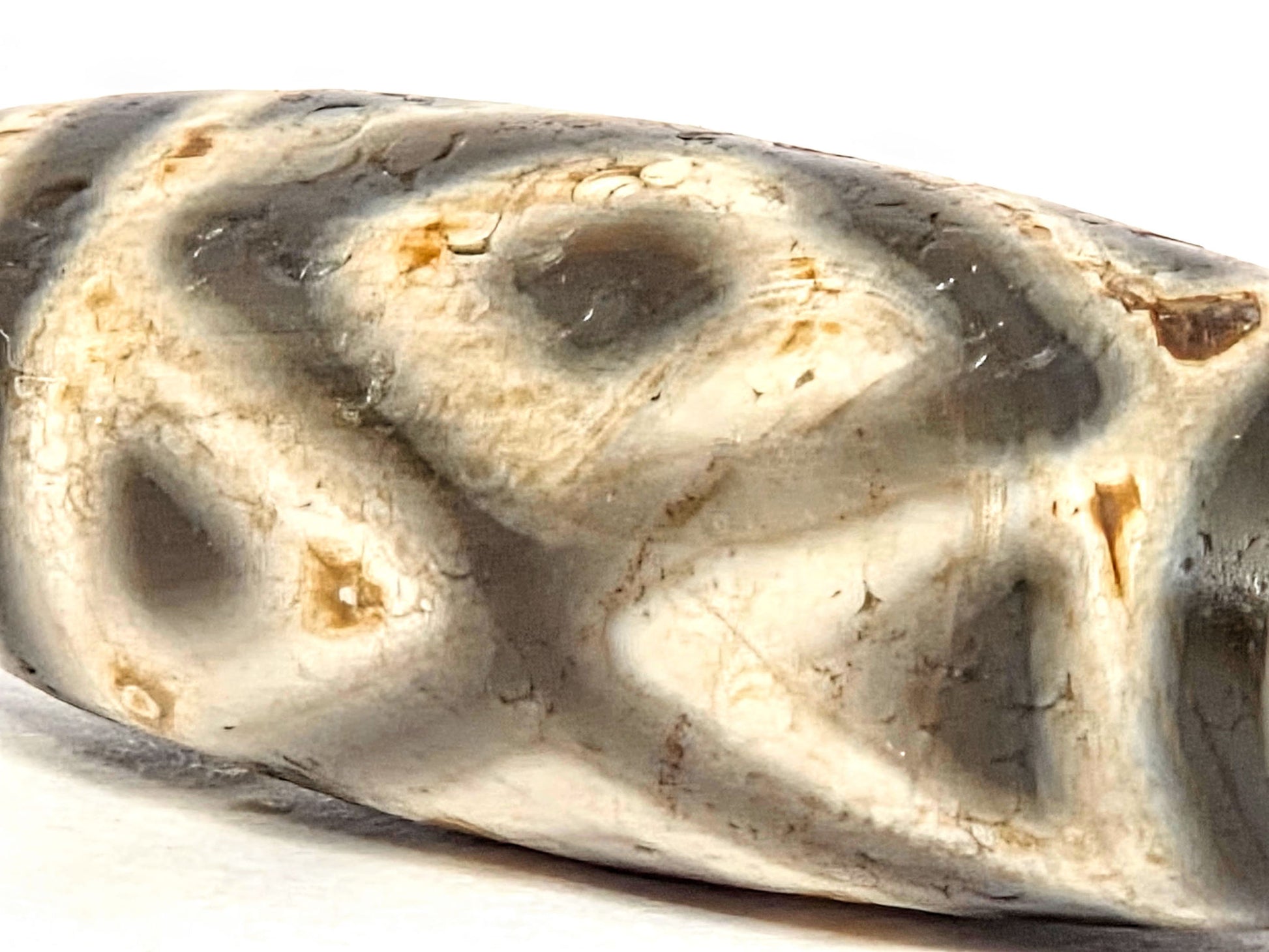 Angled close-up of ancient Three Diamond Eye Dzi bead showing depth and clarity of etching — genuine 2,000 year old Tibetan amulet