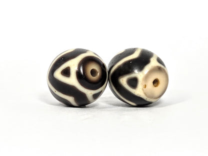 At-070626-TTW drill-end pair, Bead A warm brown end cap, Bead B cream-white end cap, tiger tooth tip elements, unretouched