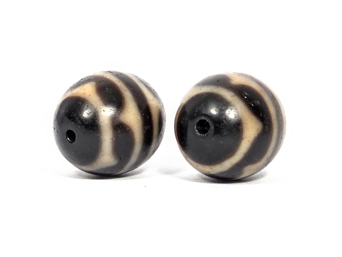 V-071426-DWP3 Double Wave pair drill-end angle B — opposite pole both beads, cream arc sweep, dark ground, unretouched. 