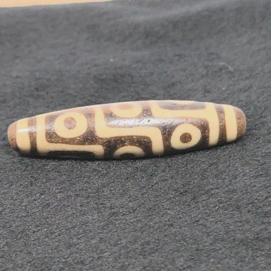 UV test of ancient nine eye dzi bead confirming authenticity — original Tibetan agate bead, Ancient Dzi Shop 032326
