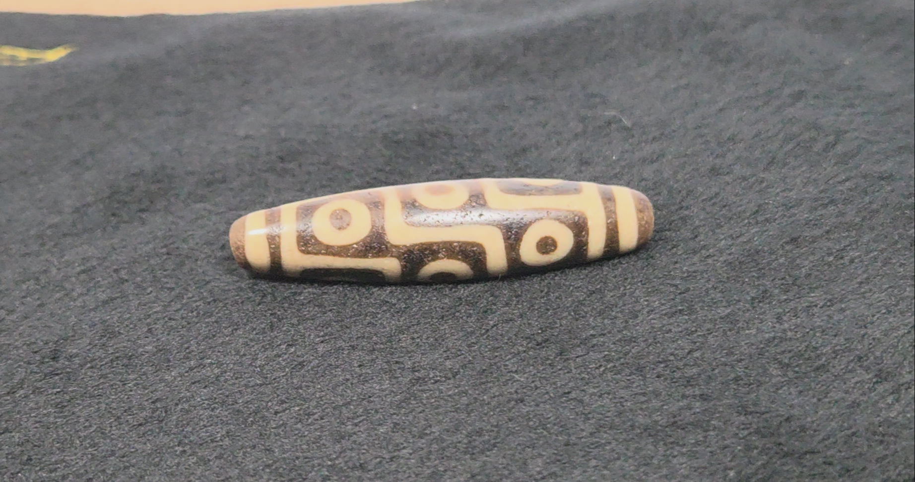 UV test of ancient nine eye dzi bead confirming authenticity — original Tibetan agate bead, Ancient Dzi Shop 032326